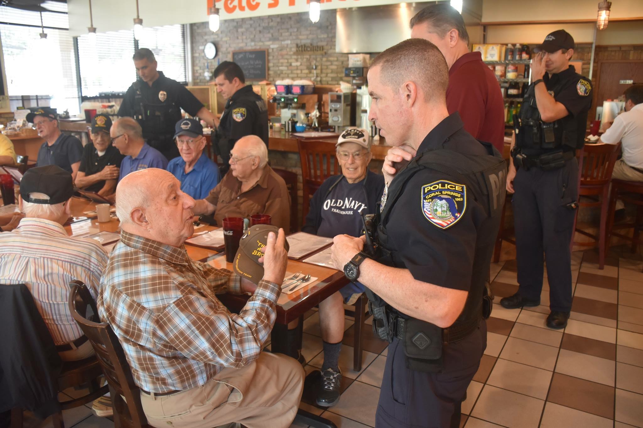 Photo courtesy of the Coral Springs Police Department; Officer Glenn Roberts meeting with members of the Park Summit Veterans Group that meets at Pete's Place every three months.